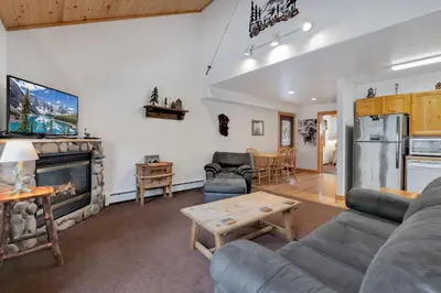 a living room with a couch and a fireplace at Bugle Pointe A03 by Estes Park Condos in Estes Park