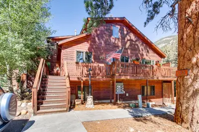 a log home with a deck and an american flag at Bugle Pointe A03 by Estes Park Condos in Estes Park