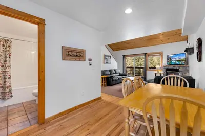 a dining room and living room with a table and chairs at Bugle Pointe A03 by Estes Park Condos in Estes Park