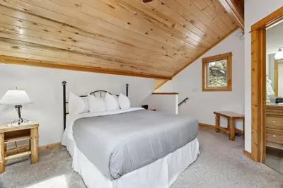 a bedroom with a bed and a wooden ceiling at Bugle Pointe A06 by Estes Park Condos in Estes Park