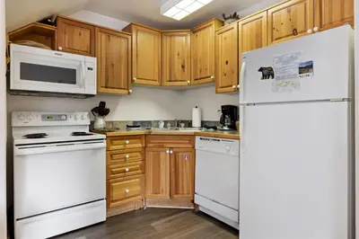 a kitchen with white appliances and wooden cabinets at Bugle Pointe A06 by Estes Park Condos in Estes Park