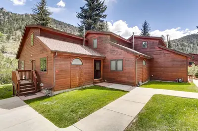 a house in the mountains with a yard at Bugle Pointe A06 by Estes Park Condos in Estes Park