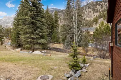 a view of a yard with trees and a house at Bugle Pointe A06 by Estes Park Condos in Estes Park