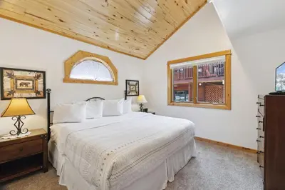 a bedroom with a large white bed and a window at Bugle Pointe A06 by Estes Park Condos in Estes Park
