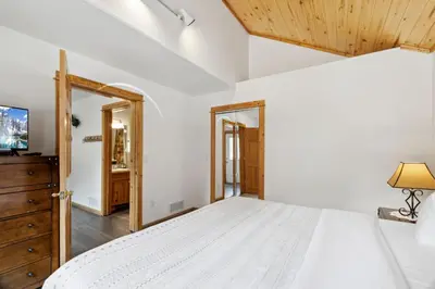 a bedroom with a white bed and a tv at Bugle Pointe A06 by Estes Park Condos in Estes Park