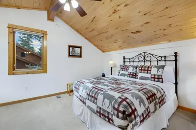 a bedroom with a bed and a wooden ceiling at Bugle Pointe A09 by Estes Park Condos in Estes Park