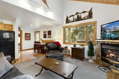 a living room with a fireplace and a tv at Bugle Pointe A09 by Estes Park Condos in Estes Park