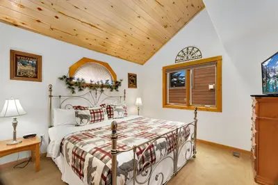 a bedroom with a bed and a wooden ceiling at Bugle Pointe A09 by Estes Park Condos in Estes Park