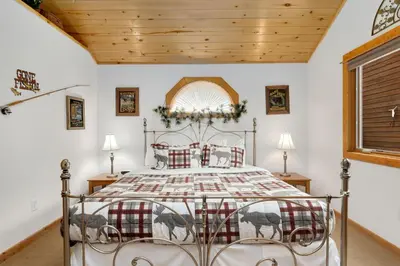 a bedroom with a bed and a wooden ceiling at Bugle Pointe A09 by Estes Park Condos in Estes Park