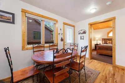 a dining room with a table and chairs and a bedroom at Bugle Pointe B11 by Estes Park Condos in Estes Park