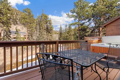 a patio with a table and chairs on a deck at Bugle Pointe B11 by Estes Park Condos in Estes Park