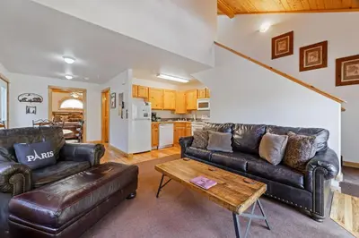a living room with two leather couches and a table at Bugle Pointe B11 by Estes Park Condos in Estes Park