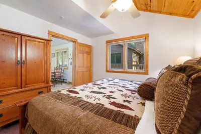 a bedroom with a bed and a dresser and a window at Bugle Pointe B11 by Estes Park Condos in Estes Park