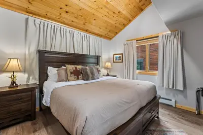 a bedroom with a large bed and a wooden ceiling at Bugle Pointe B13 by Estes Park Condos in Estes Park