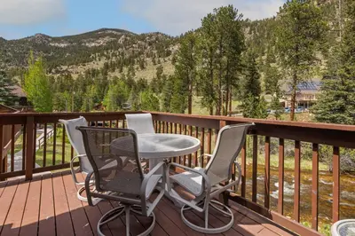 a balcony with a table and two chairs on a deck at Bugle Pointe B13 by Estes Park Condos in Estes Park
