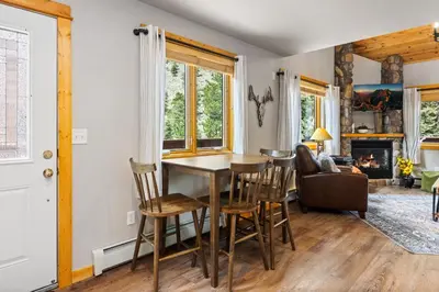 a dining room and living room with a table and chairs at Bugle Pointe B13 by Estes Park Condos in Estes Park
