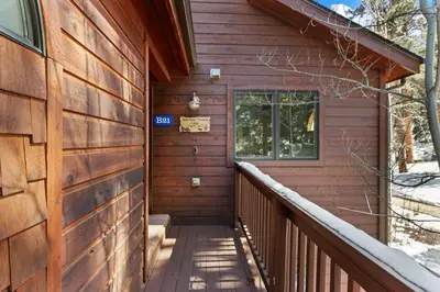 a wooden house with a snowy walkway to the front door at Bugle Pointe B21 by Estes Park Condos in Estes Park