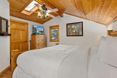 a bedroom with a white bed and a ceiling fan at Bugle Pointe B21 by Estes Park Condos in Estes Park