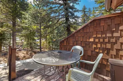 a patio with a table and chairs on a deck at Creekside Condos D by Estes Park Condos in Estes Park