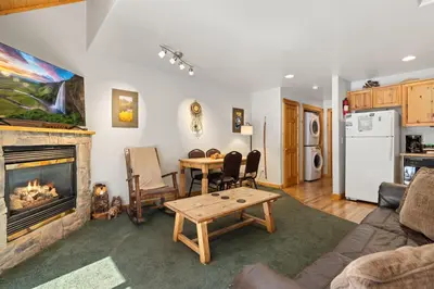 a living room with a fireplace and a table at Creekside Condos D by Estes Park Condos in Estes Park