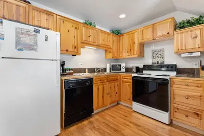 a kitchen with wooden cabinets and black and white appliances at Creekside Condos D by Estes Park Condos in Estes Park