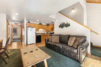 a living room with a couch and a kitchen at Creekside Condos D by Estes Park Condos in Estes Park