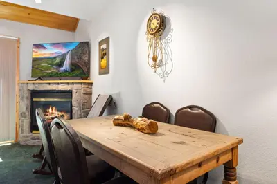 a dining room with a wooden table and a fireplace at Creekside Condos D by Estes Park Condos in Estes Park