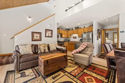 a living room with a couch and chairs and a kitchen at Creekside Condos H by Estes Park Condos in Estes Park