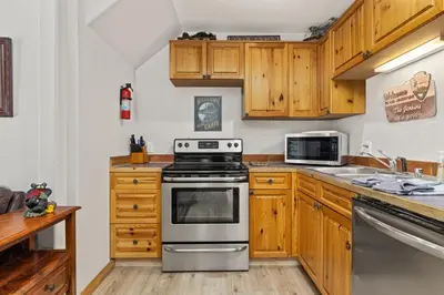 a kitchen with wooden cabinets and a stove at Creekside Condos H by Estes Park Condos in Estes Park