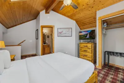 a bedroom with a large bed and a wooden ceiling at Creekside Condos H by Estes Park Condos in Estes Park