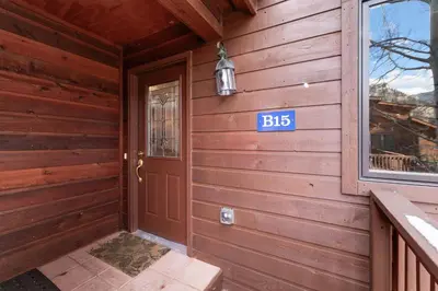 a door to a cabin with a sign on it at Bugle Pointe B15 by Estes Park Condos in Estes Park