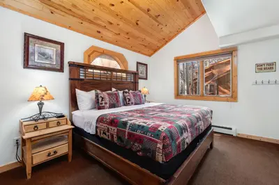 a bedroom with a bed and a night stand with a lamp at Bugle Pointe B15 by Estes Park Condos in Estes Park