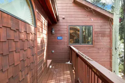 a wooden building with a balcony and a window at Bugle Pointe B15 by Estes Park Condos in Estes Park