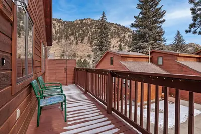 a wooden balcony with a bench on a house at Bugle Pointe A04 by Estes Park Condos in Estes Park