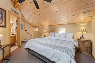 a bedroom with a large bed and a wooden ceiling at Bugle Pointe A04 by Estes Park Condos in Estes Park