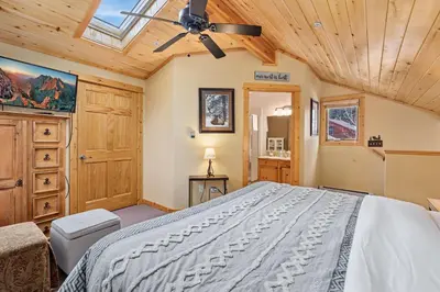 a bedroom with a large bed and a skylight at Bugle Pointe A04 by Estes Park Condos in Estes Park