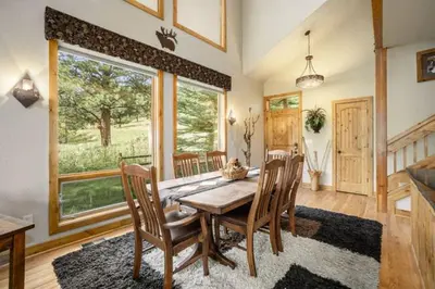 a dining room with a wooden table and chairs at Elk River Cabin -- Cabin Condo in Estes Park -- 23-ZONE3554 condo in Estes Park