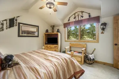 a bedroom with a bed and a ceiling fan at Elk River Cabin -- Cabin Condo in Estes Park -- 23-ZONE3554 condo in Estes Park