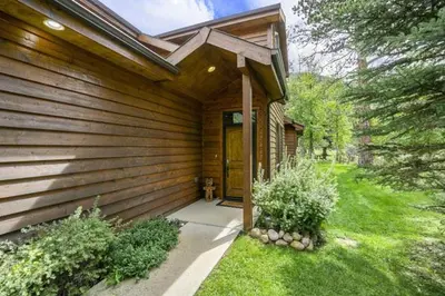 a wooden house with a door in a yard at Elk River Cabin -- Cabin Condo in Estes Park -- 23-ZONE3554 condo in Estes Park