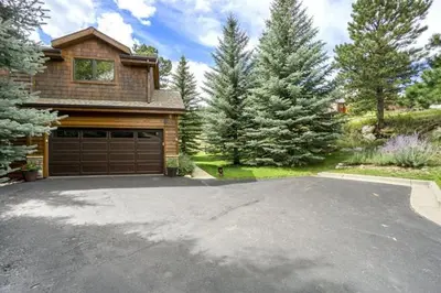a house with a garage and a driveway at Elk River Cabin -- Cabin Condo in Estes Park -- 23-ZONE3554 condo in Estes Park