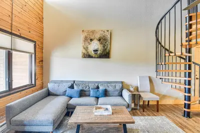 a living room with a couch with a wolf picture on the wall at Hot Tub and Indoor Pool Access at Granby Condo in Granby