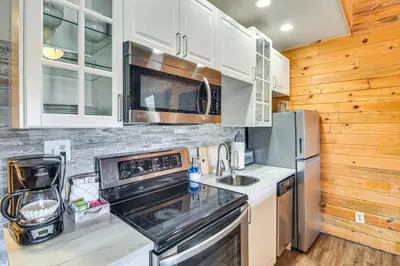 a kitchen with white cabinets and a stainless steel refrigerator at Hot Tub and Indoor Pool Access at Granby Condo in Granby