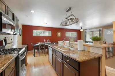 a large kitchen with red walls and a kitchen island at Arvada home w hot tub & BBQ in Arvada