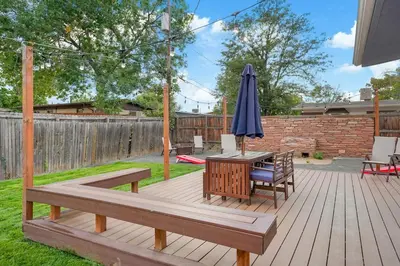 a patio with an umbrella and a table and a bench at Arvada home w hot tub & BBQ in Arvada