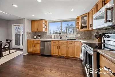 a kitchen with wooden cabinets and stainless steel appliances at Spacious home w game room & firepit in Arvada