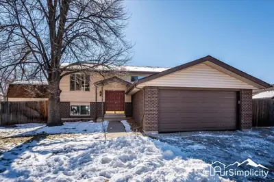 a house with a garage in the snow at Spacious home w game room & firepit in Arvada