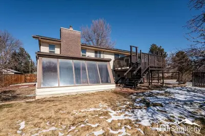 a house with a porch and a deck at Spacious home w game room & firepit in Arvada