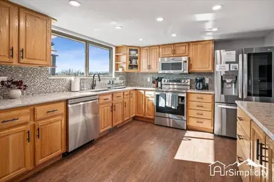 a kitchen with wooden cabinets and stainless steel appliances at Spacious home w game room & firepit in Arvada