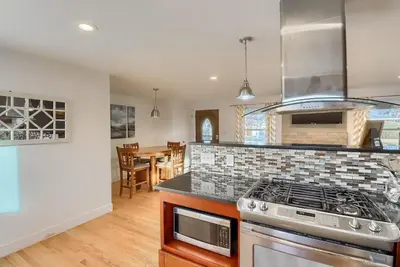 a kitchen with a stove and a dining room at Group-Friendly 4-Bedroom Denver Home w Backyard in Centennial
