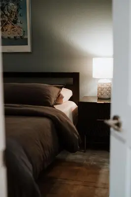 a bedroom with a bed and a table with a lamp at Modern home w hot tub & game room in Centennial